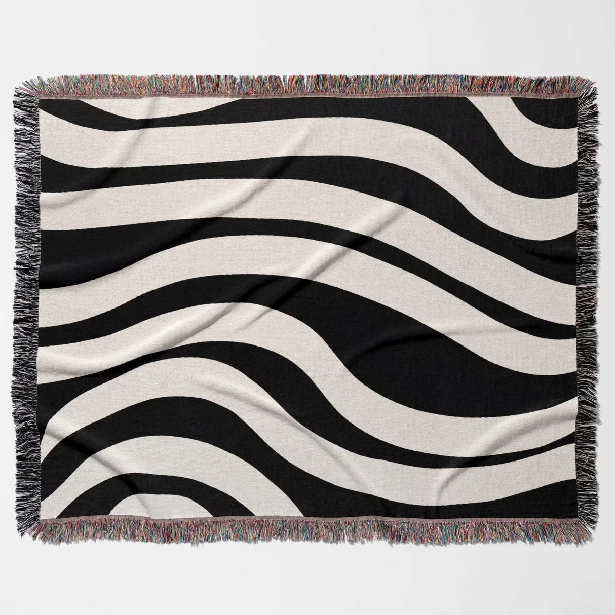 Black and white abstract shapes woven blanket throw tapestry flat lay on a plain background.