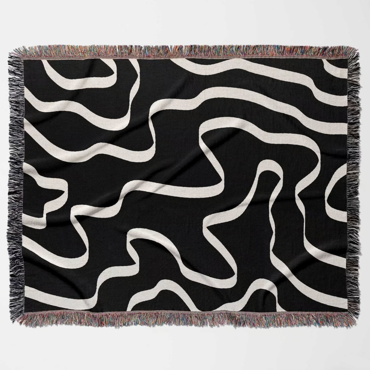 Black and white abstract waves artistic woven blanket throw flat lay on a white background