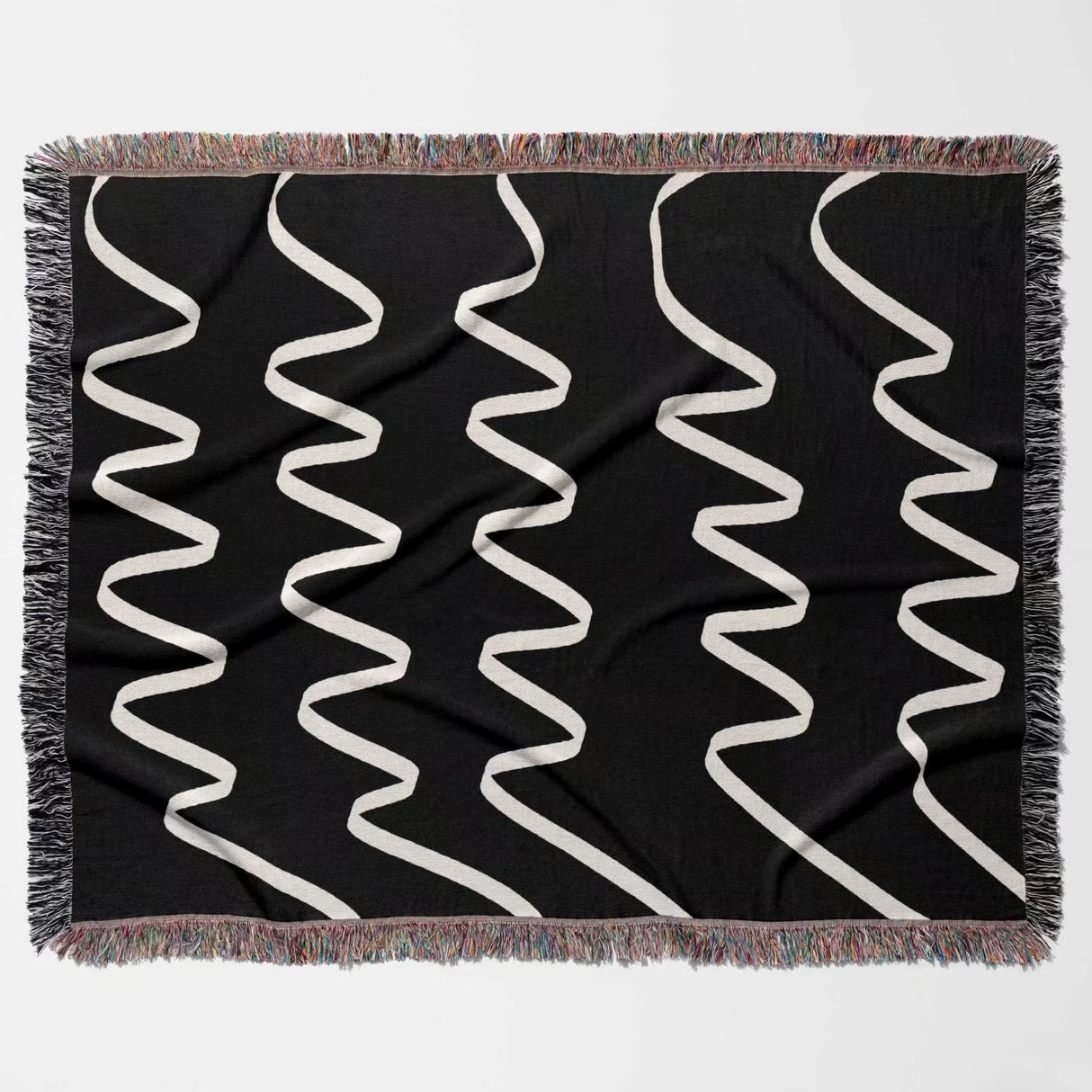 Black and white accent decorative woven blanket throw tapestry with white wavy lines flat lay on a white background
