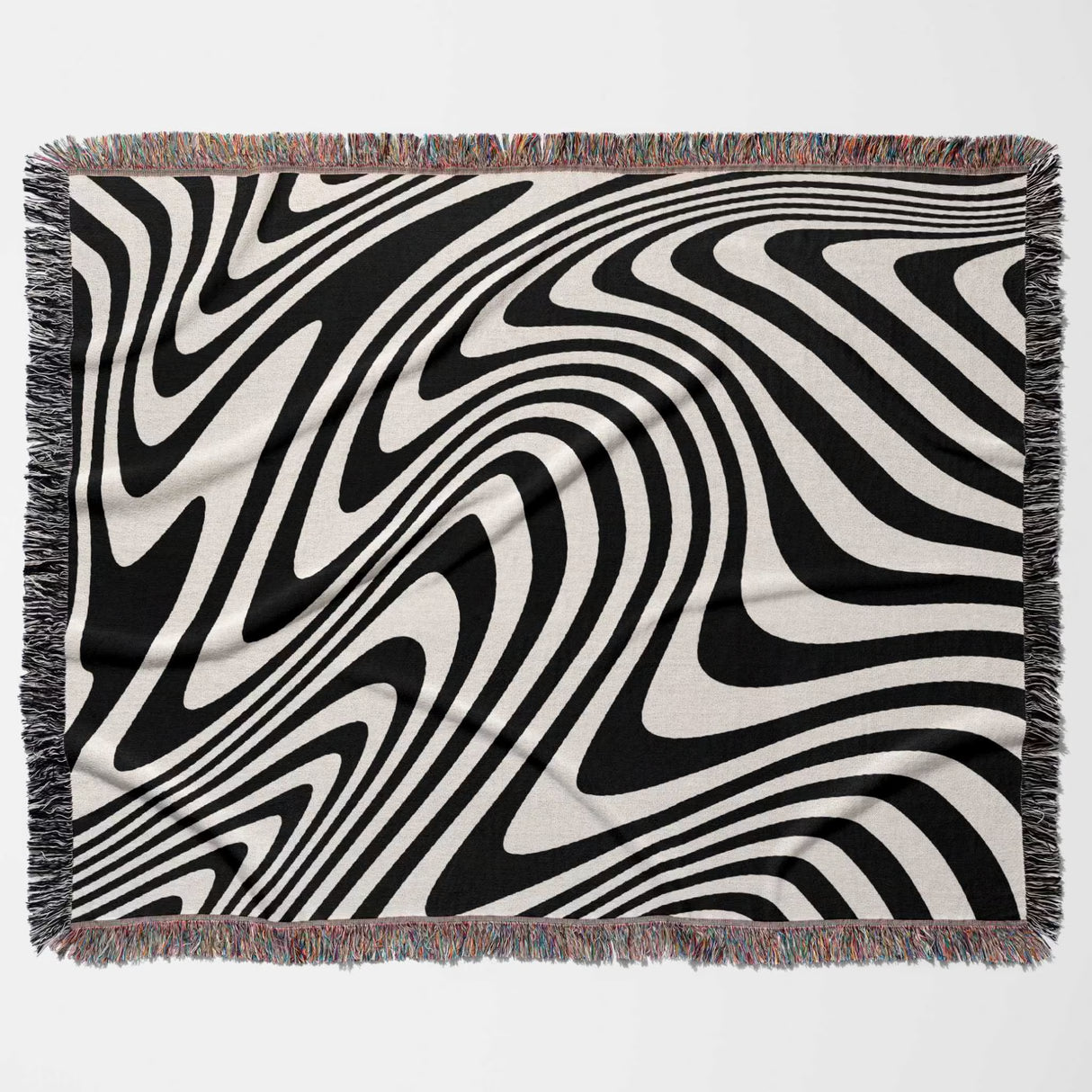 black and white modern couch woven throw blanket with fringed edges on a light gray background
