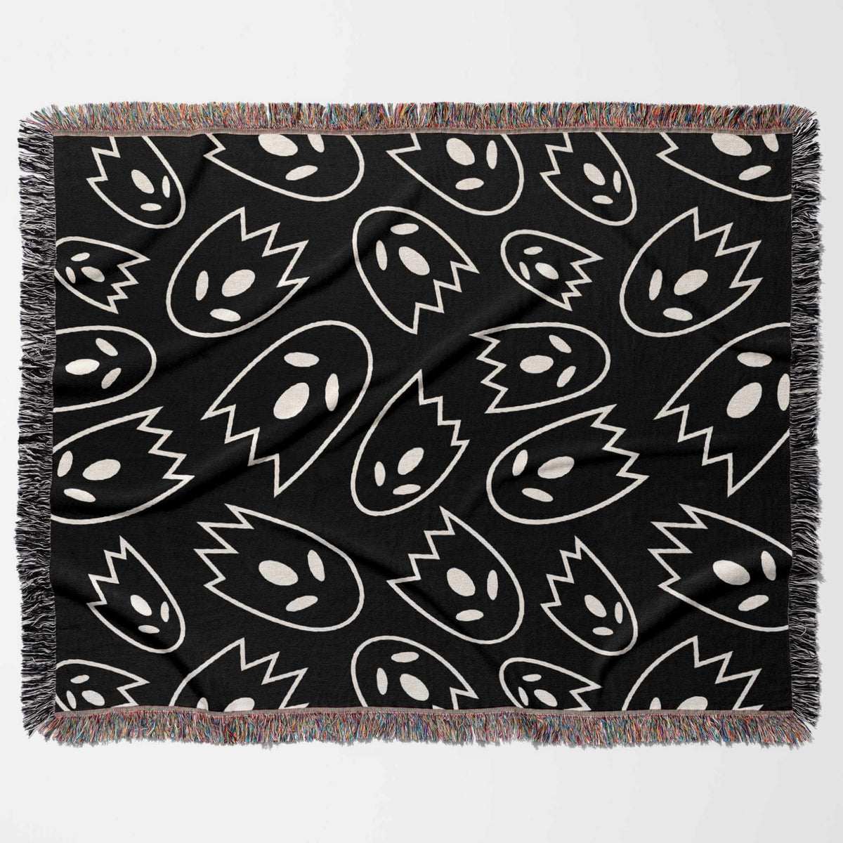 Black blanket with white abstract ghost pattern on a white background