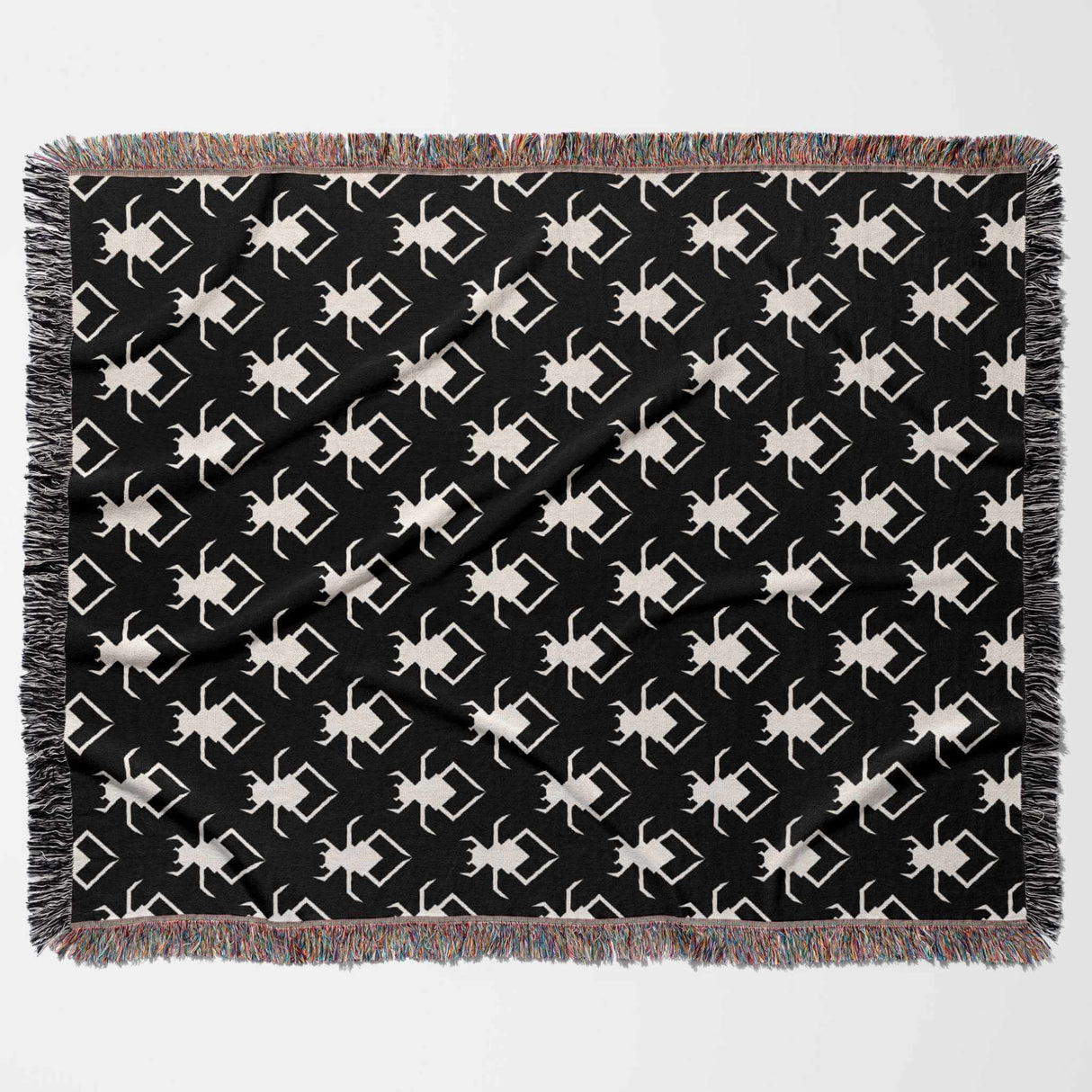 Black and white geometric spiders pattern woven throw blanket flat lay on a white background.