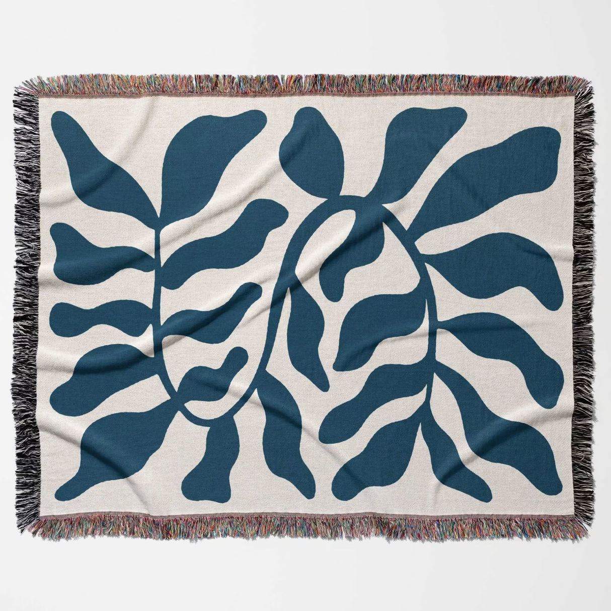 Blue leaf Matisse throw blanket flat lay on a beige background