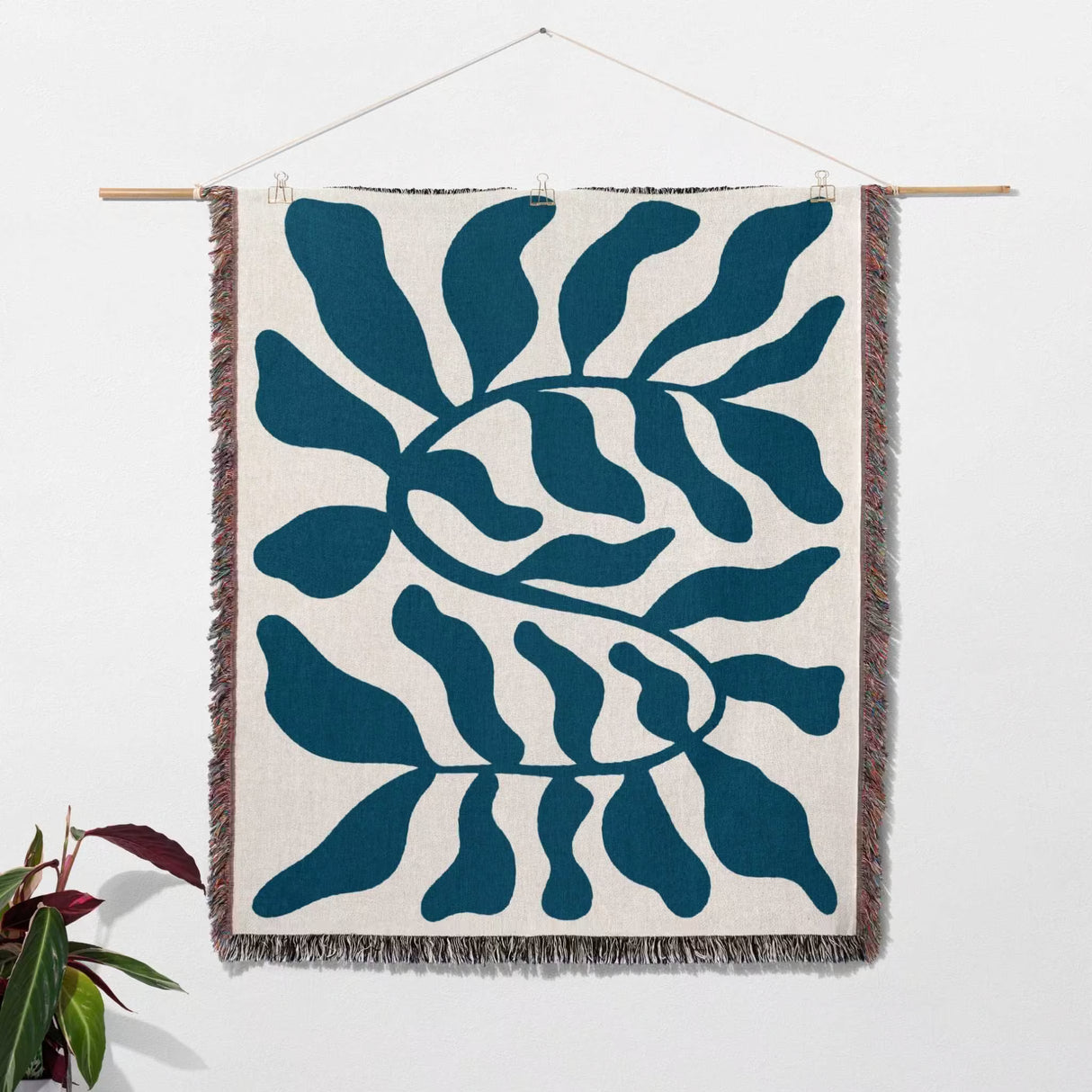 Blue leaf Matisse throw blanket as a woven wall art hanging on a white background