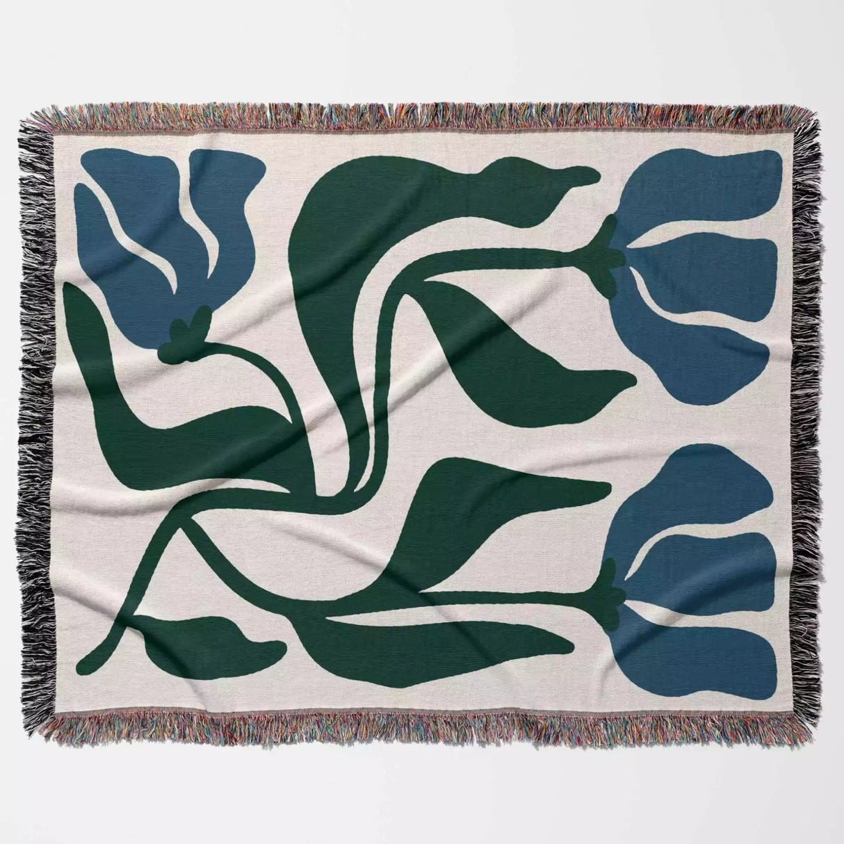 Floral patterned blue and green Matisse flower woven throw blanket with blue and green flowers on a beige background