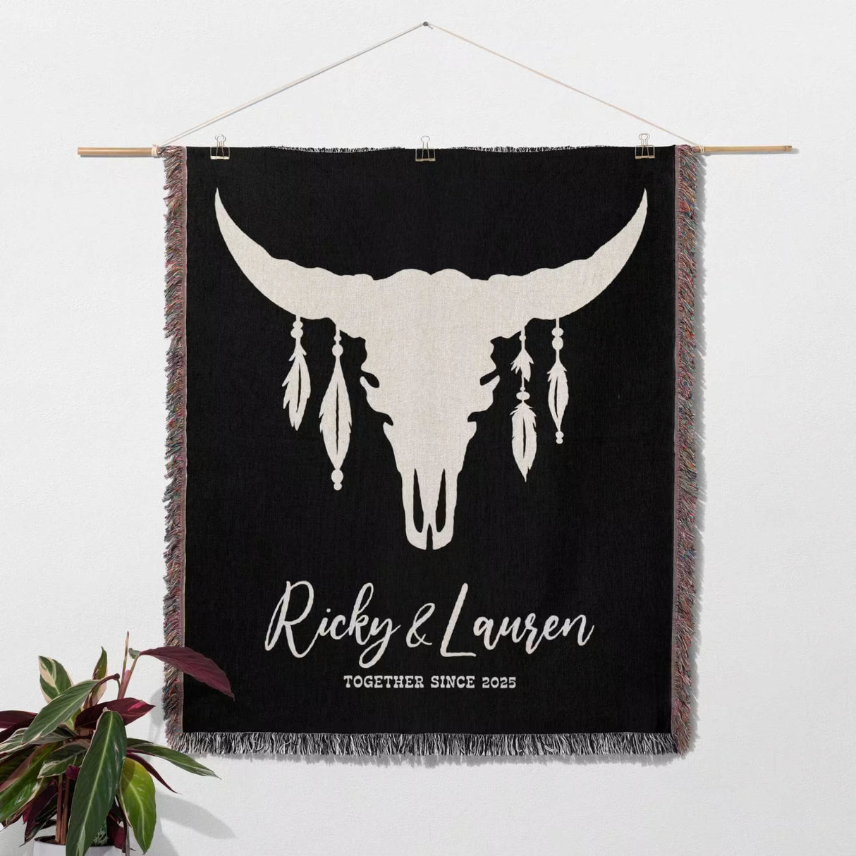 Bull skull boho wedding 2nd anniversary gift woven throw blanket with white bull skull design and text 'Ricky & Lauren Together Since 2023' on a white wall.