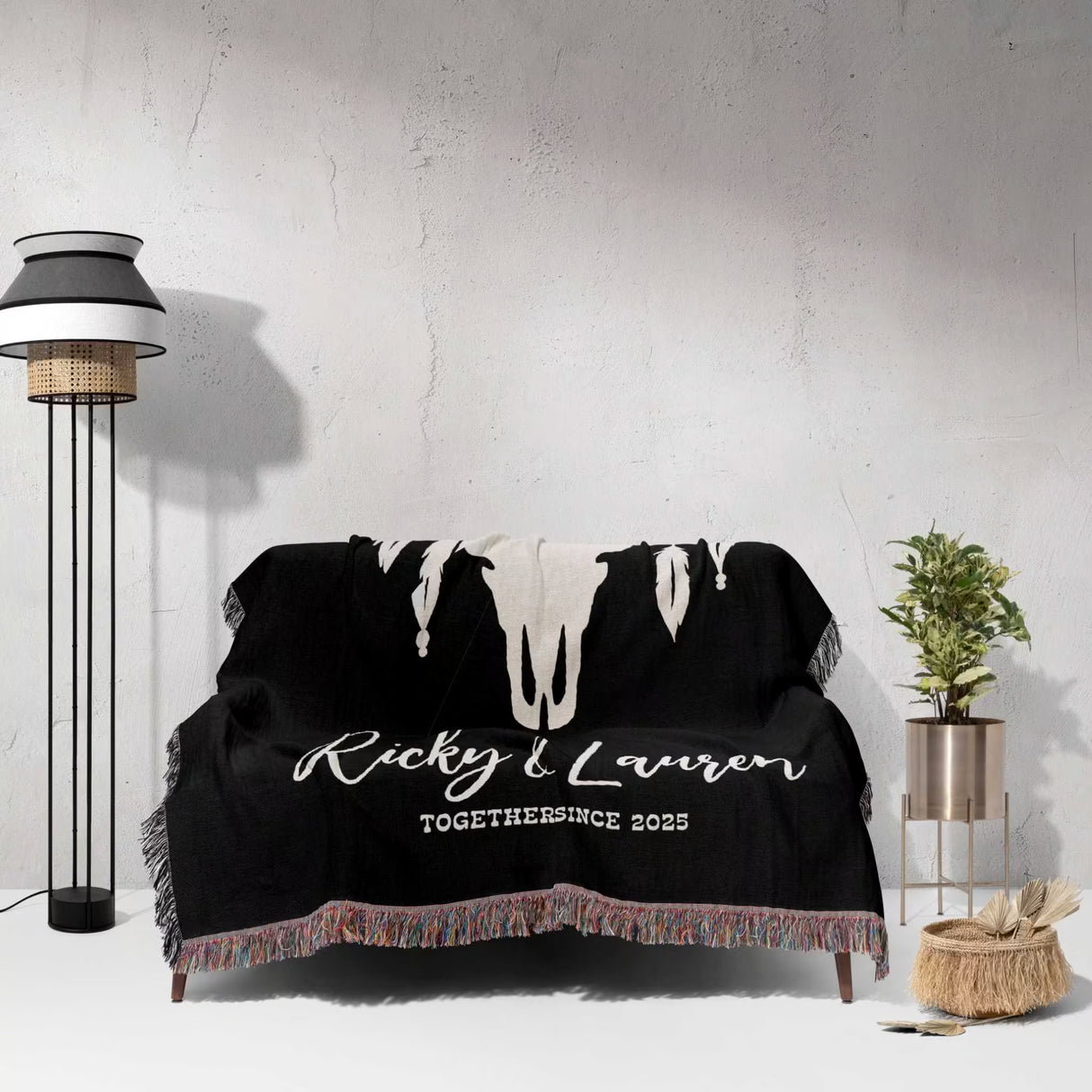Bull skull boho wedding 2nd anniversary gift woven throw blanket with white text on a couch against a white wall.