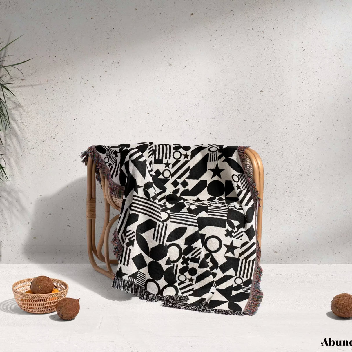 Black and white classical checker board pattern woven blanket throw on a wooden chair against a light background.