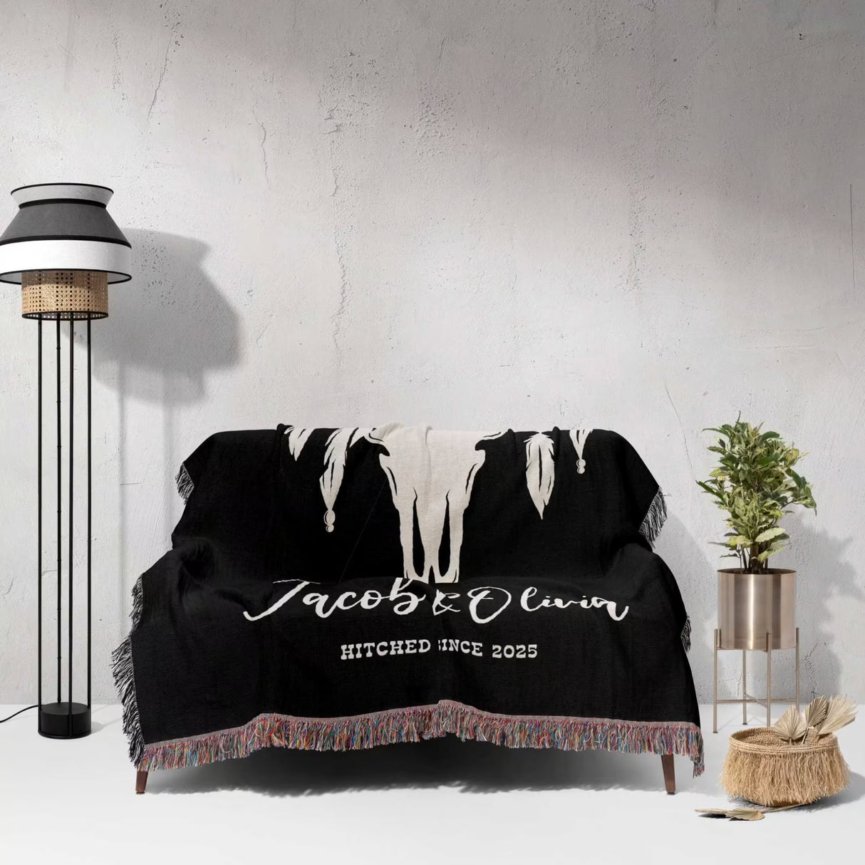 Cow skull wedding 2nd anniversary gift woven throw blanket with 'Jacob & Olivia HITCHED SINCE 2025' custom text draped over a couch in a room setting.