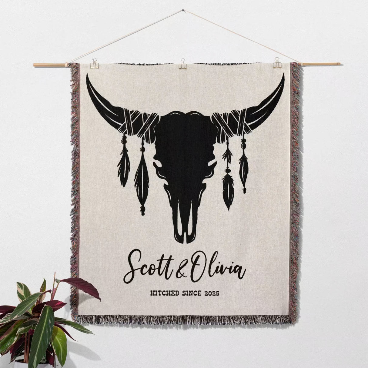 Cow skull wedding cotton anniversary gift woven throw blanket as wall tapestry with bull skull design and personalized text, hanging on a white wall.
