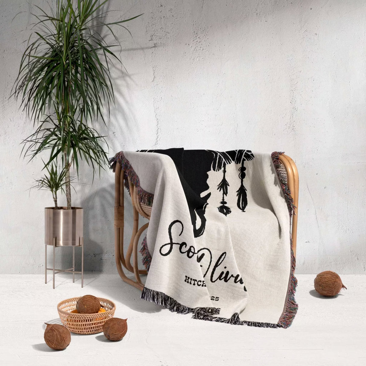 Cow skull wedding cotton anniversary gift woven throw blanket with text draped over a chair next to a plant on a light background