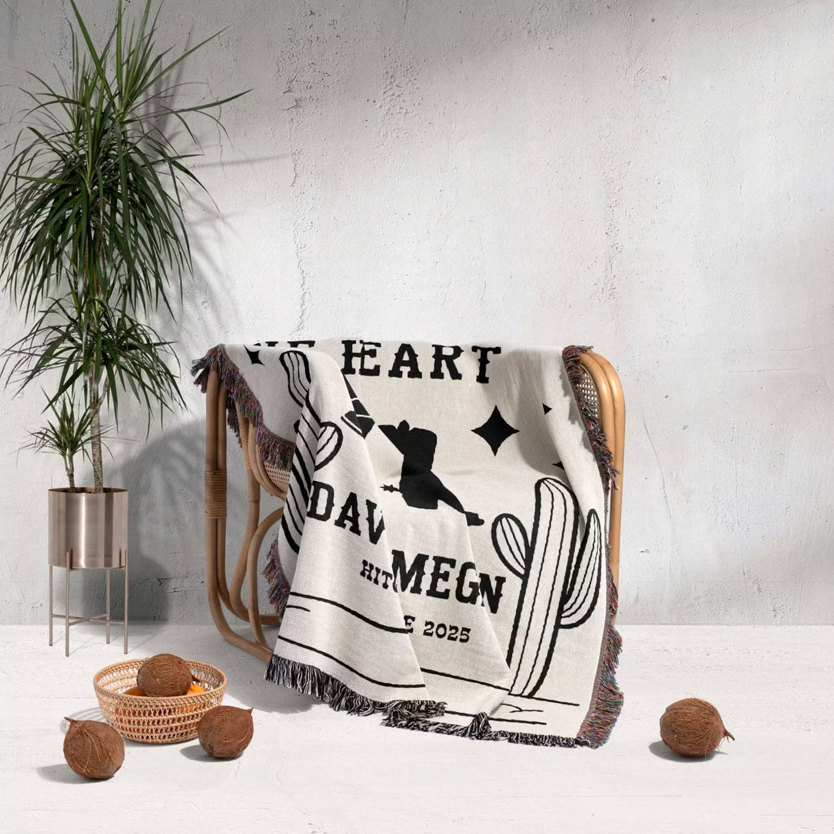 Cowboy boots wedding cotton anniversary gift woven throw blanket with text and graphics draped over a chair against a white wall with a plant and decorative items.