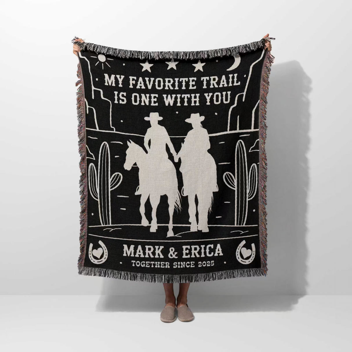 Cowboy and cowgirl couple 2nd anniversary gift woven throw blanket held by a person with cowboy design and text on a white background