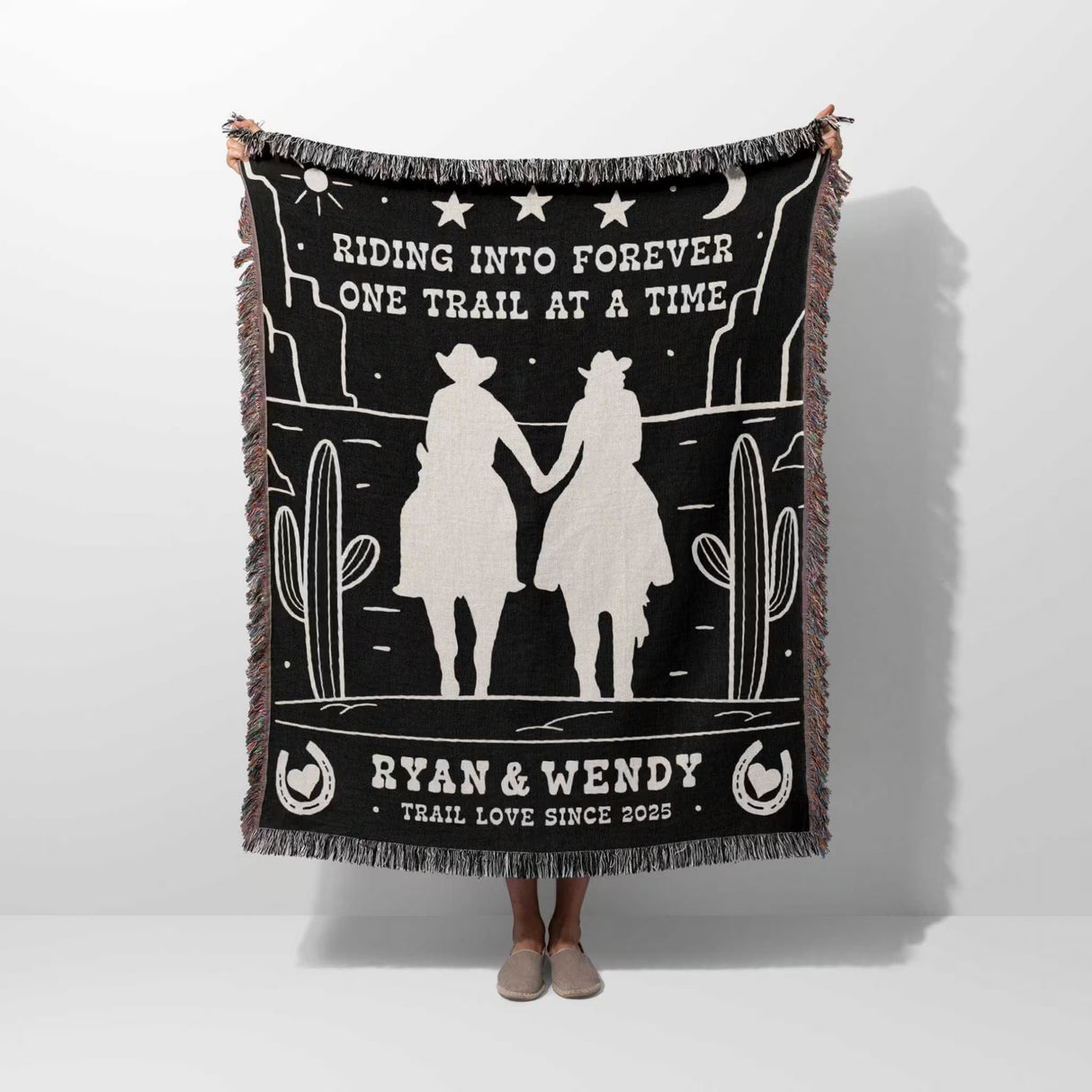 Cowboy and cowgirl western 2nd anniversary gift woven throw blanket with desert design and text, held by a person on a white background