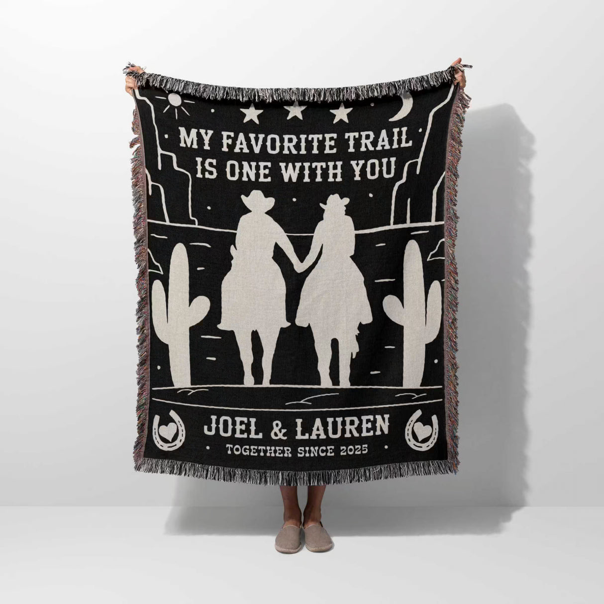 Cowboy and cowgirl on two horses 2nd anniversary gift woven throw blanket with desert-themed design and text, held by a person on a white background
