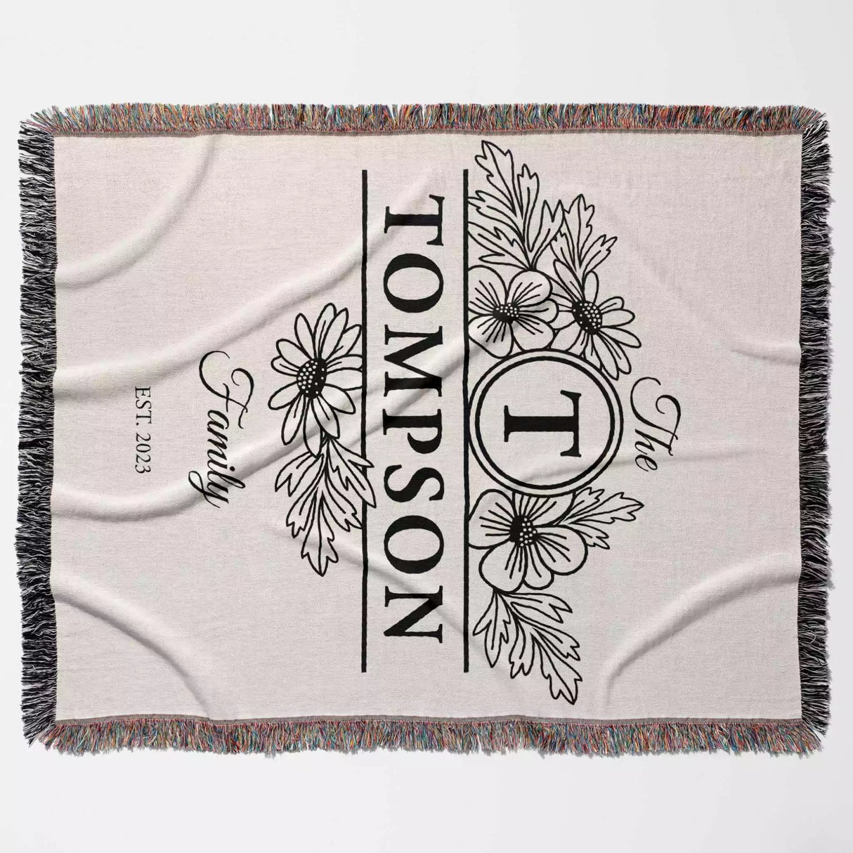 Custom family name blanket with floral design and 'Tompson' text full view on a light background