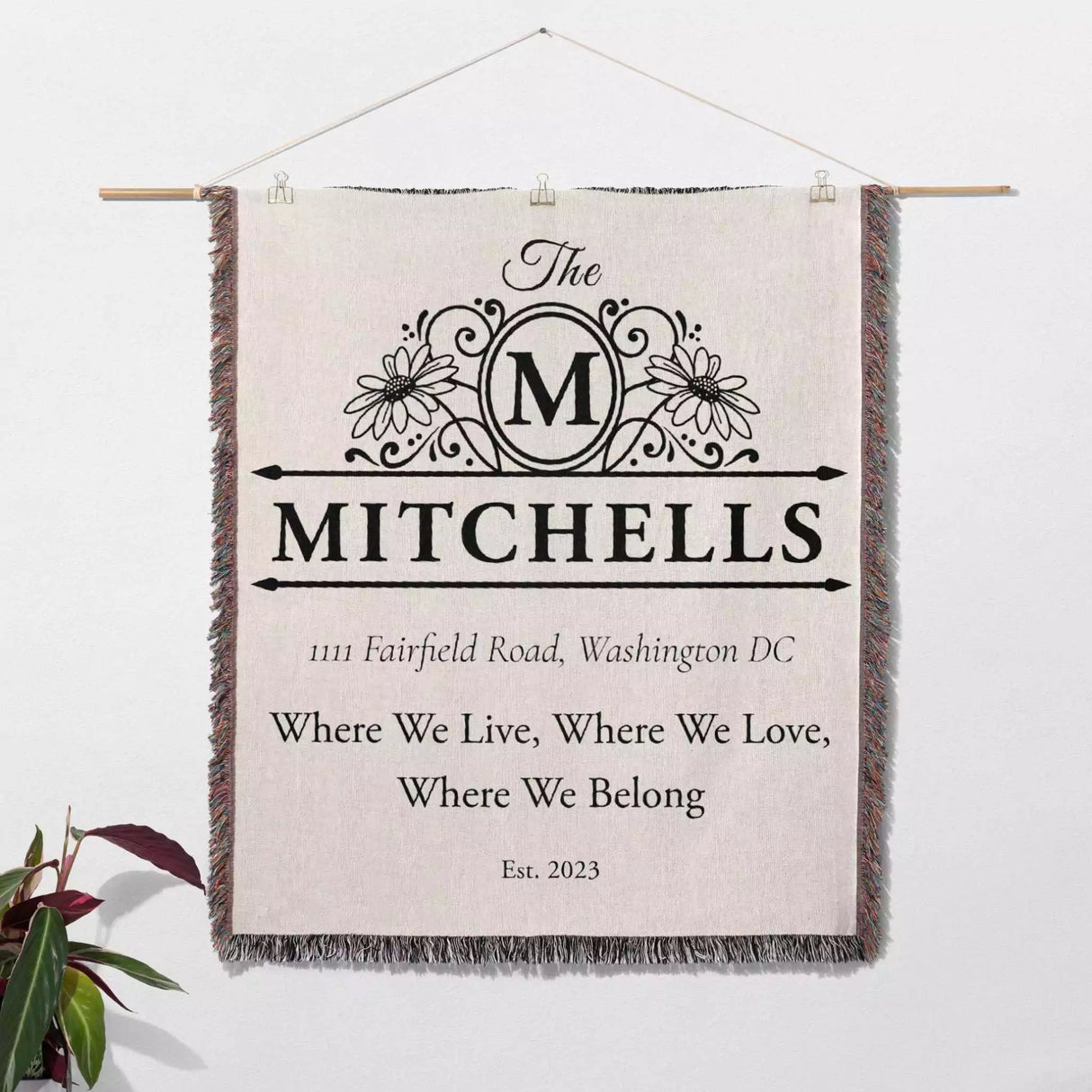 Custom family name and address blanket wall hanging with 'The Mitchells' family name and address on a light background.