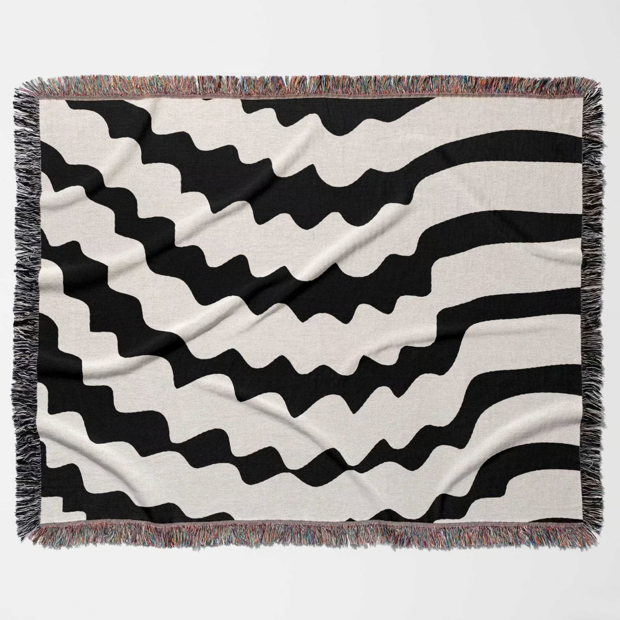 Black and white decorative abstract wavy woven blanket throw flat lay on a plain background