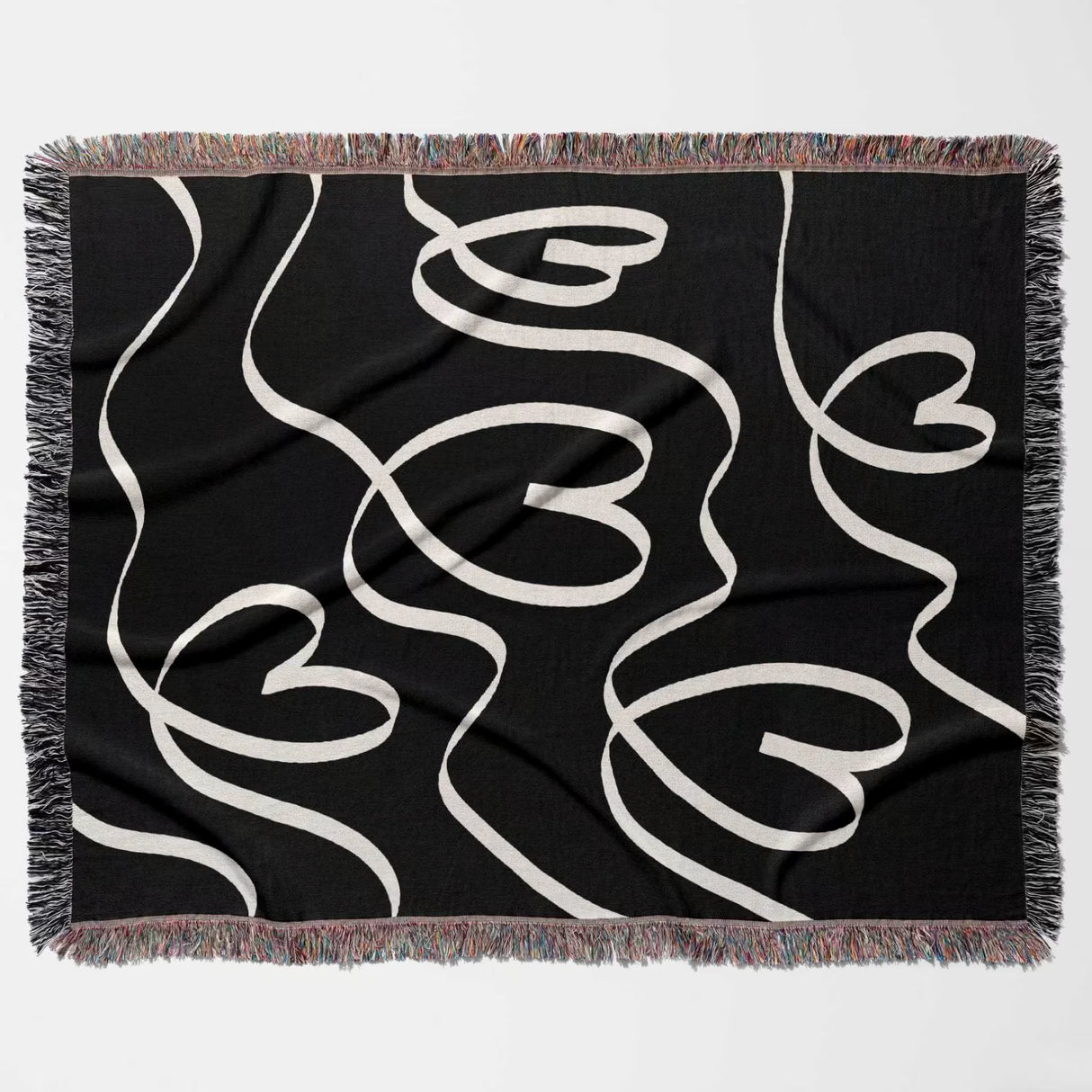 Black and white decorative hearts woven blanket throw flat lay on a white background