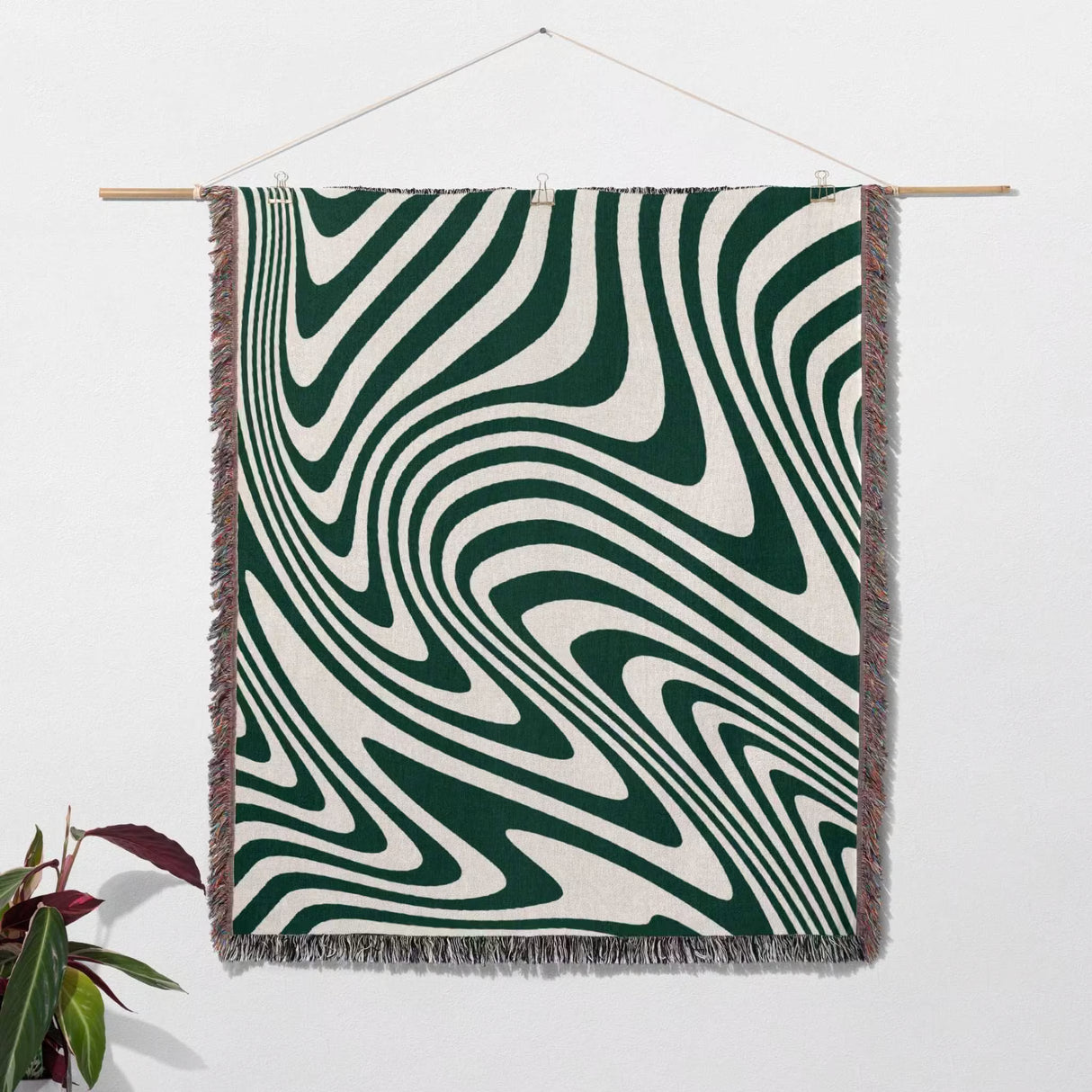 Forest green modern decorative woven throw blanket with green and white pattern hanging on a wall as a large wall wart tapestry.