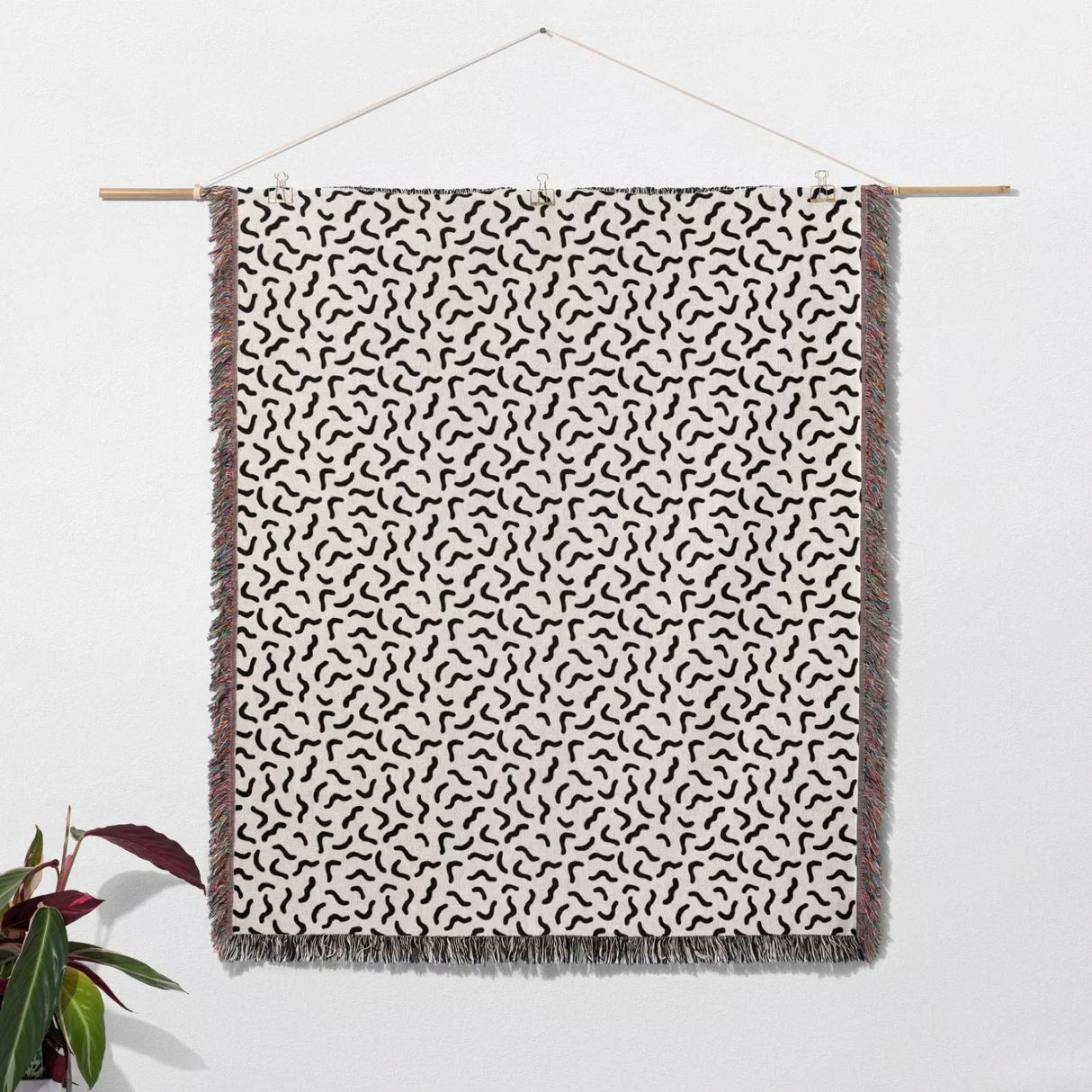 Funky squiggly woven blanket throw tapestry with black abstract pattern on a white background.