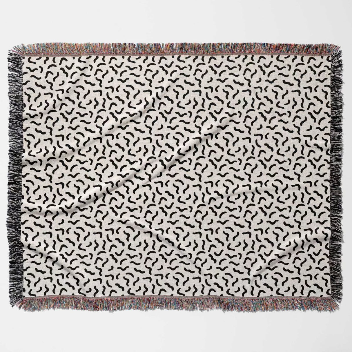 Funky squiggly woven blanket throw tapestry flat lay with black wavy lines on a white background