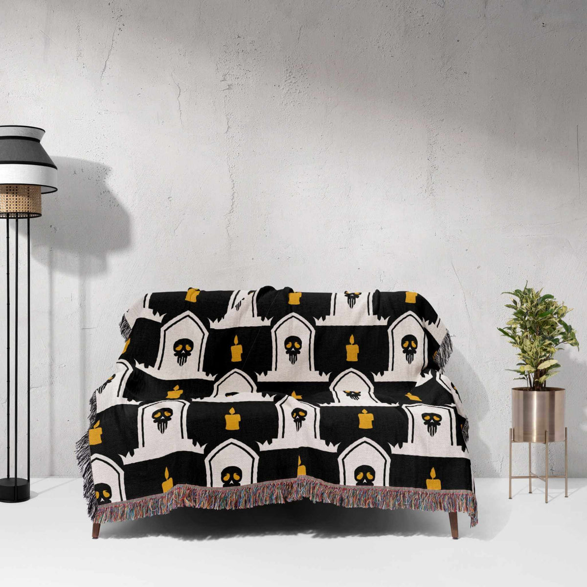 Black and white patterned throw blanket draped over a chair against a white wall.