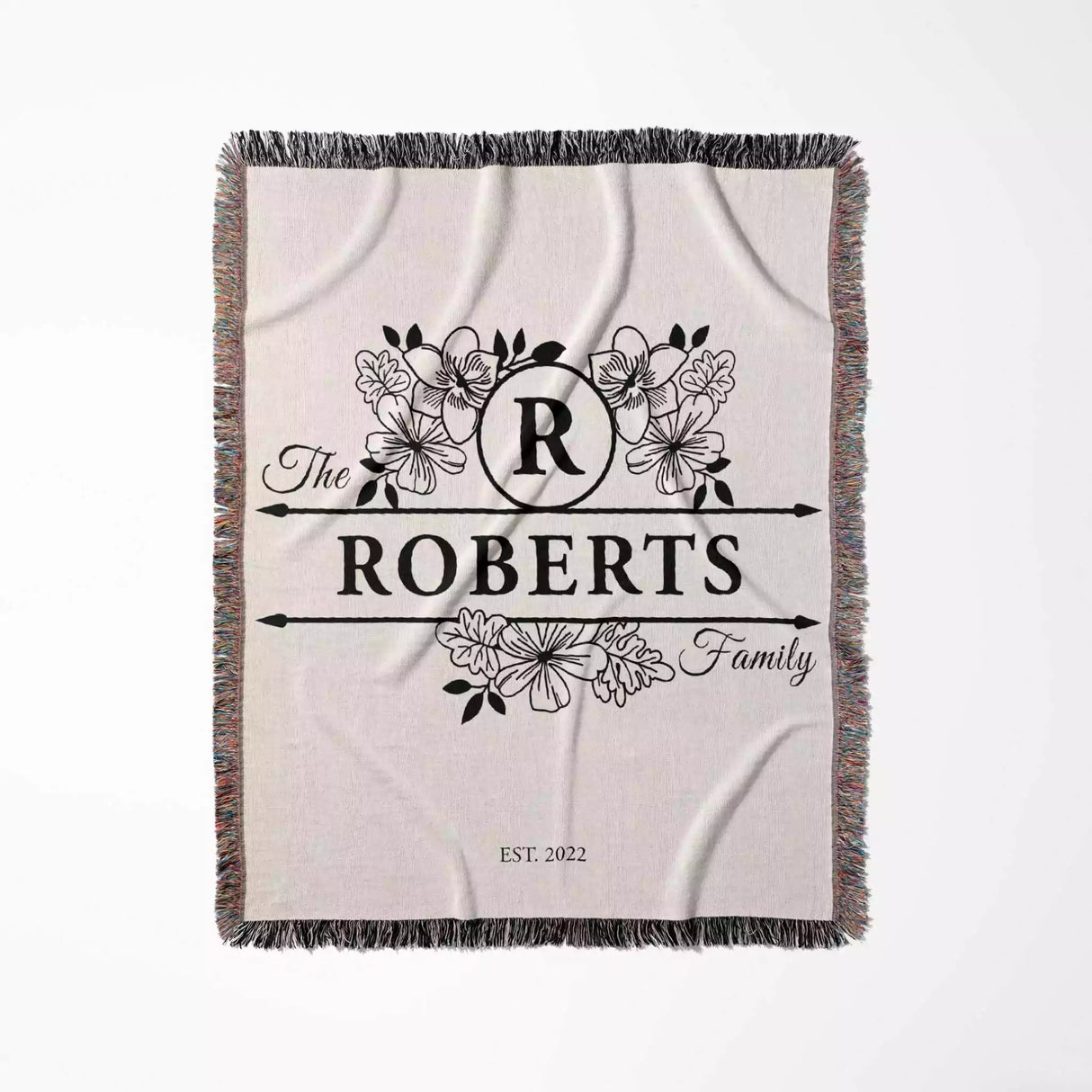 Last name monogram blanket with floral design and 'The Roberts Family' text on a white background