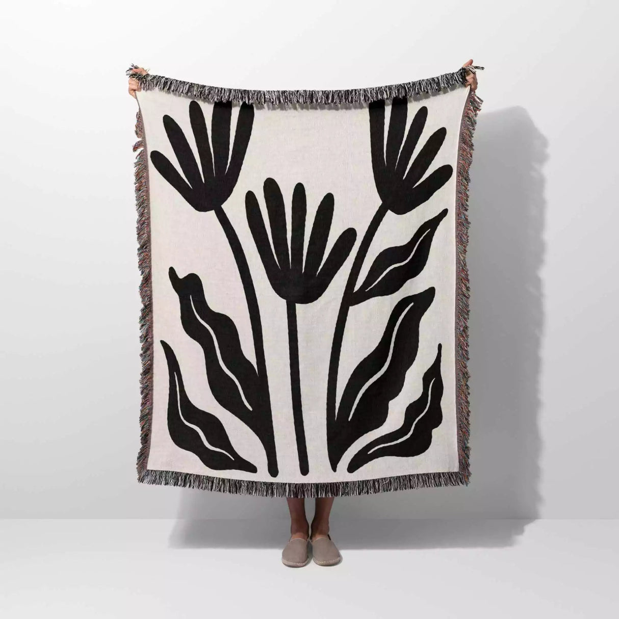Matisse flowers black and white woven throw blanket with black leaf pattern on a white background