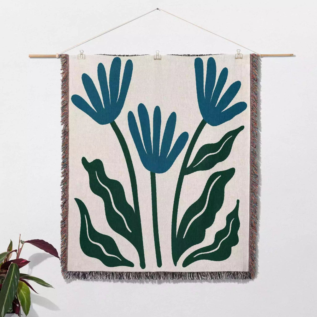 Matisse inspired blue flowers woven throw blanket as woven wall art with blue and green floral design on a white background