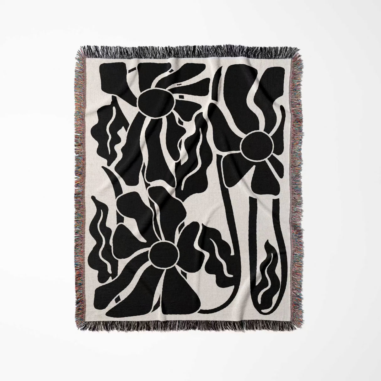 Matisse style black and white botanical cotton woven throw blanket with black and white design on a beige background