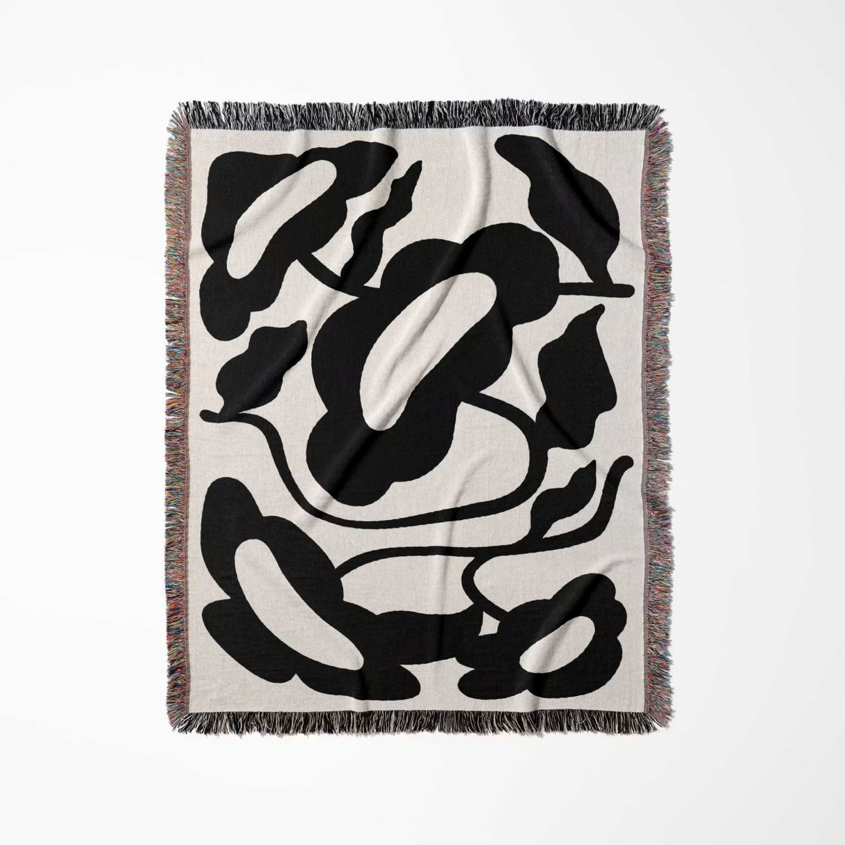 Matisse style black and white cotton woven throw blanket with black floral patterns on a white background