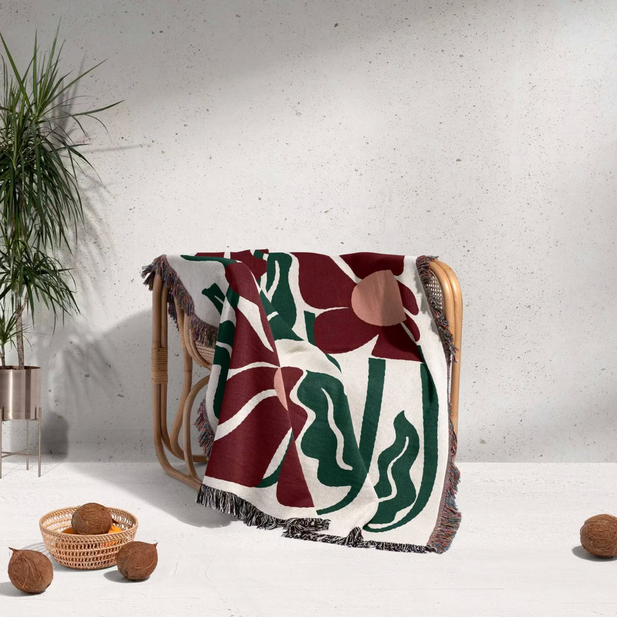 Decorative Matisse style blue pure cotton woven throw blanket with floral pattern draped over a chair against a light background