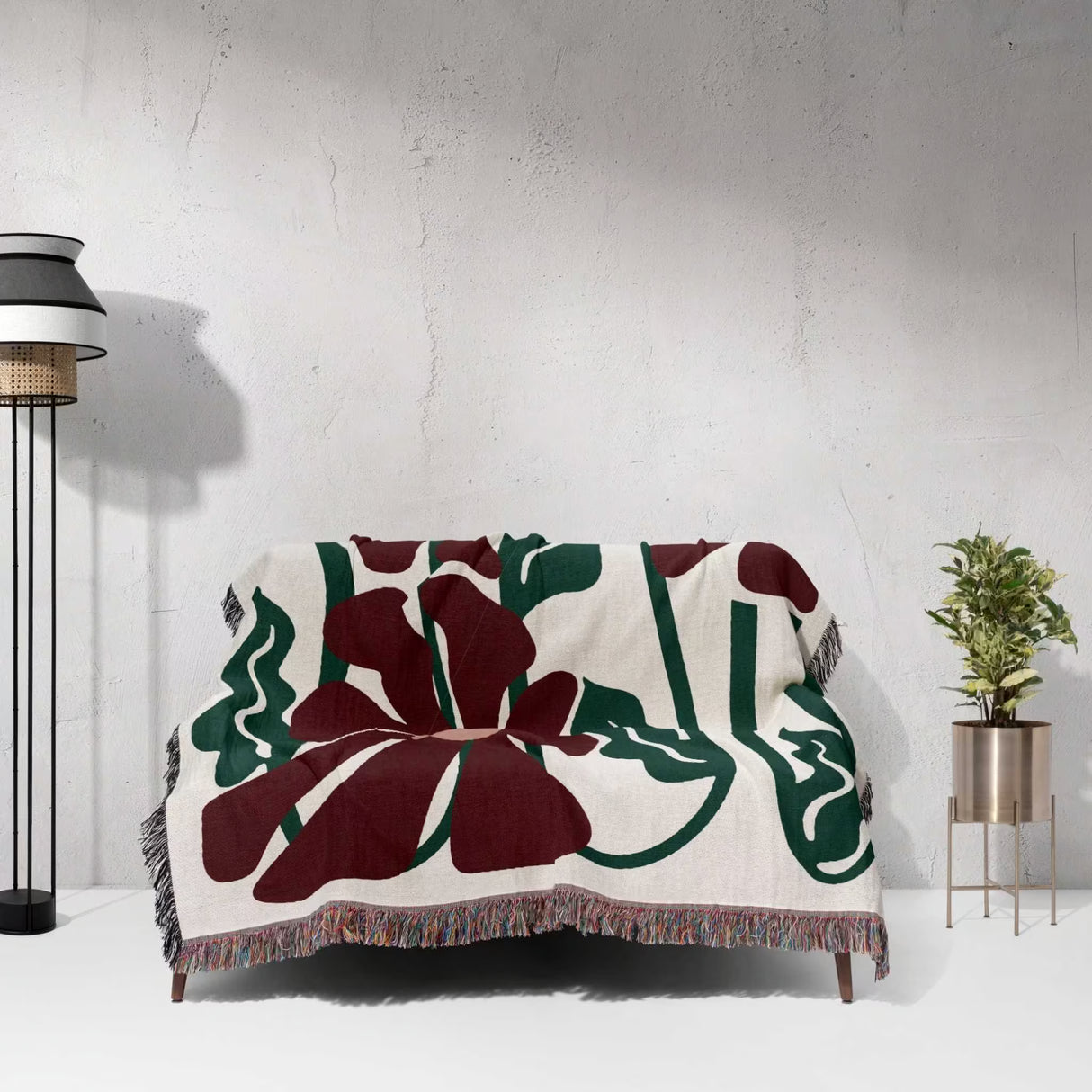 Decorative Matisse style blue pure cotton woven throw blanket with floral pattern draped over a chair against a white wall.