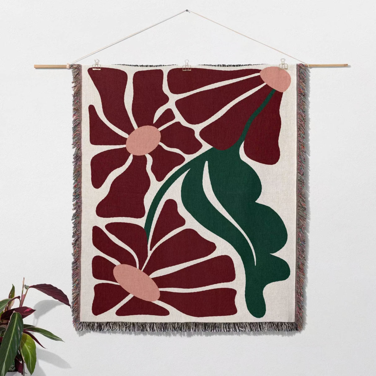 Matisse style botanical cotton woven throw blanket as woven wall art with floral design on a white background
