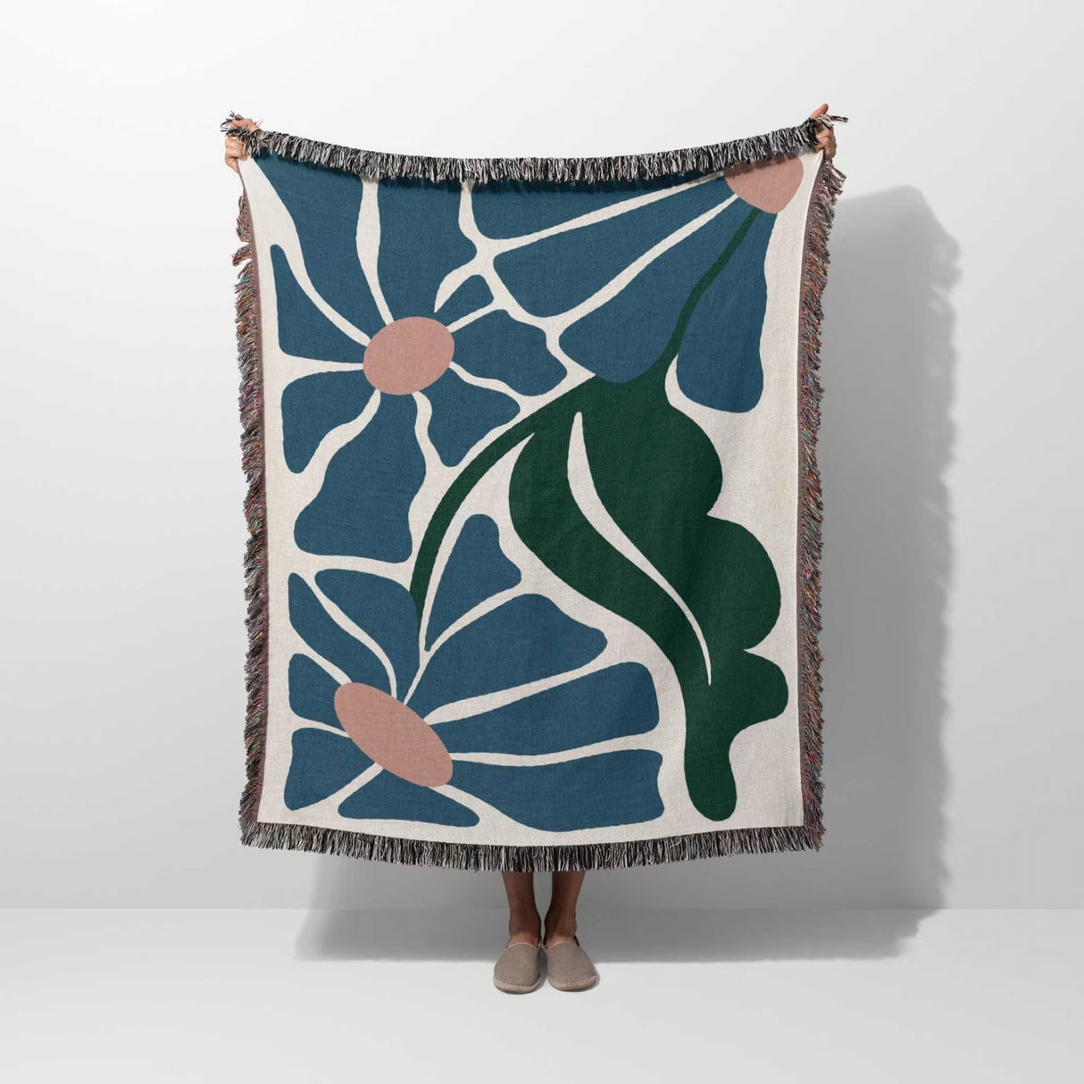 Matisse style floral cotton woven throw blanket for couch draped over a person on a white background