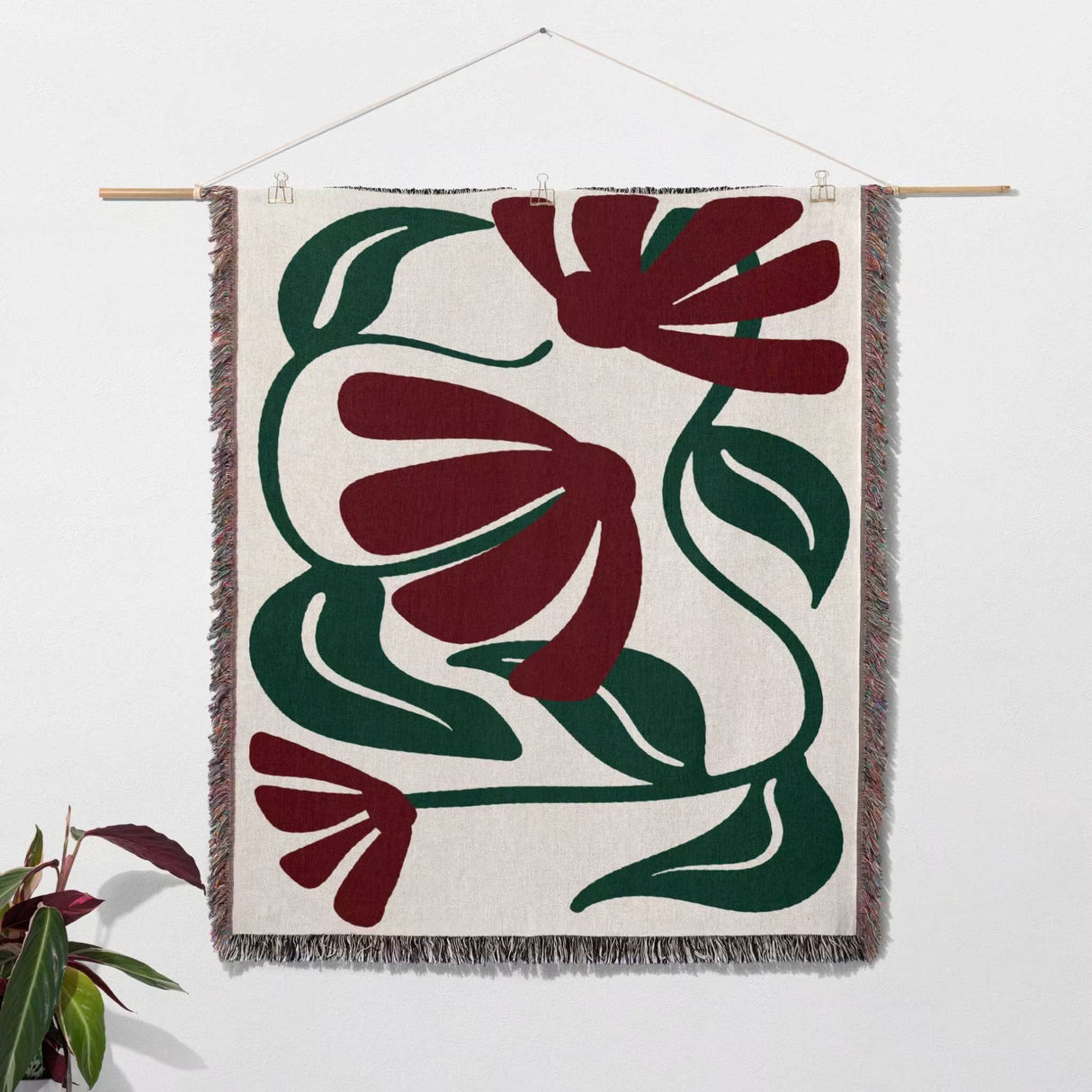 Matisse style red floral cotton woven throw blanket as woven wall art with red and green floral patterns on a white background