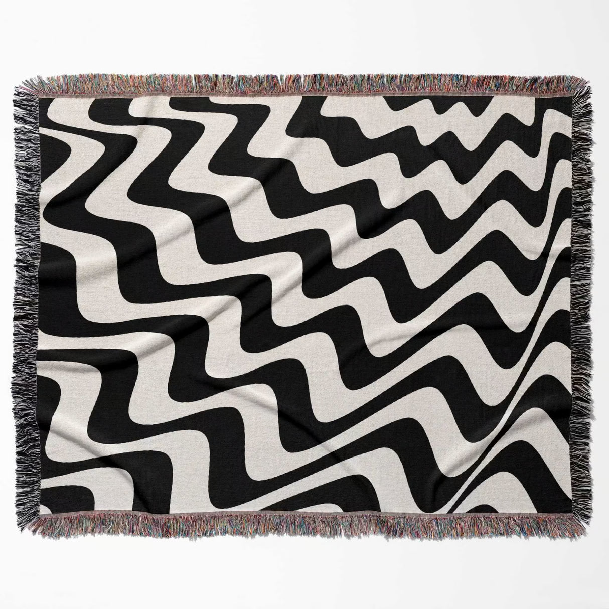 Black and white modern abstract waves woven blanket throw tapestry flat lay on a beige background.