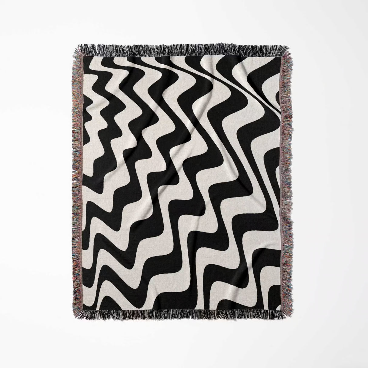 Black and white modern abstract waves woven blanket throw tapestry flat lay on a light gray background.