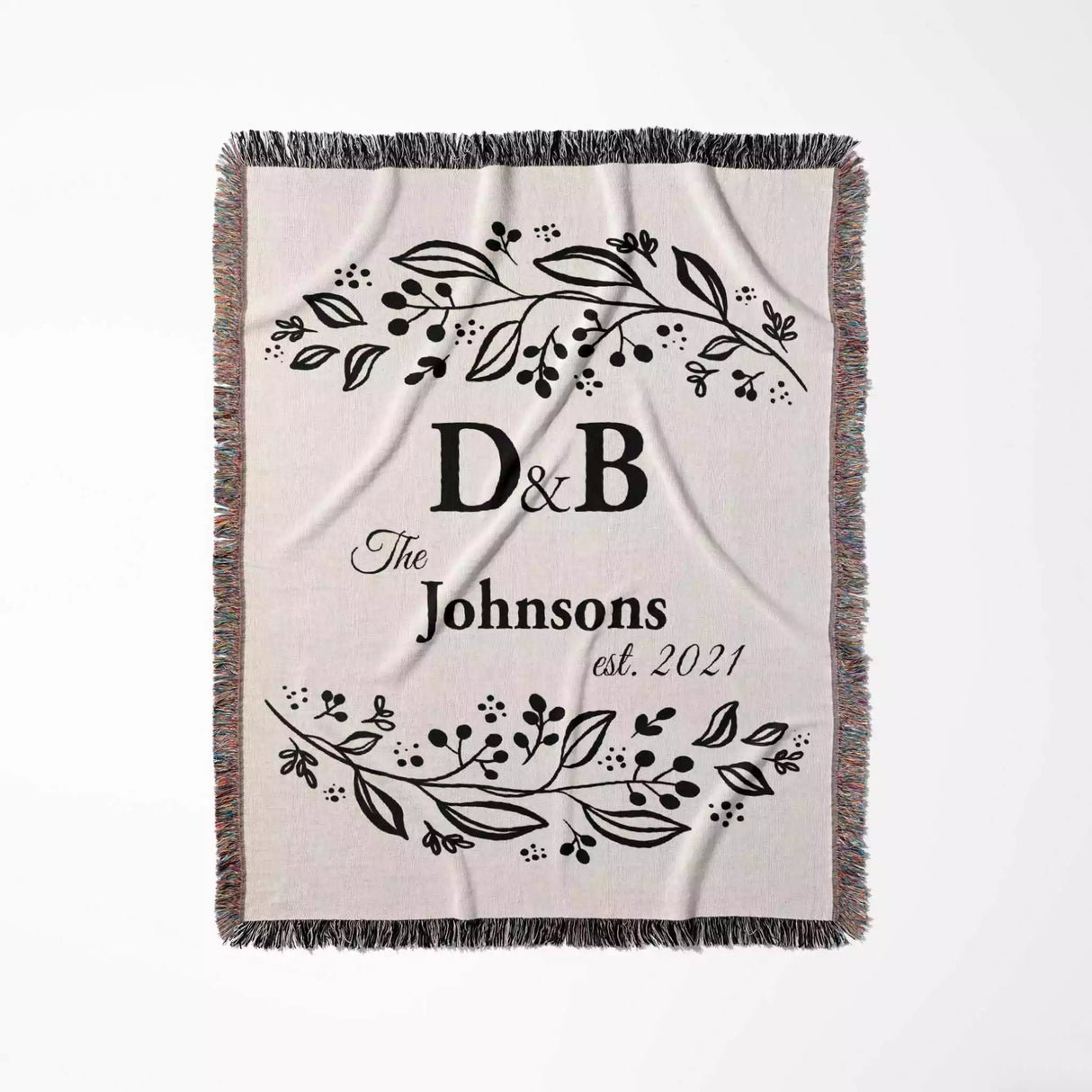 Monogrammed cotton throw blanket perfect engagement and wedding gift flat lay on a white background