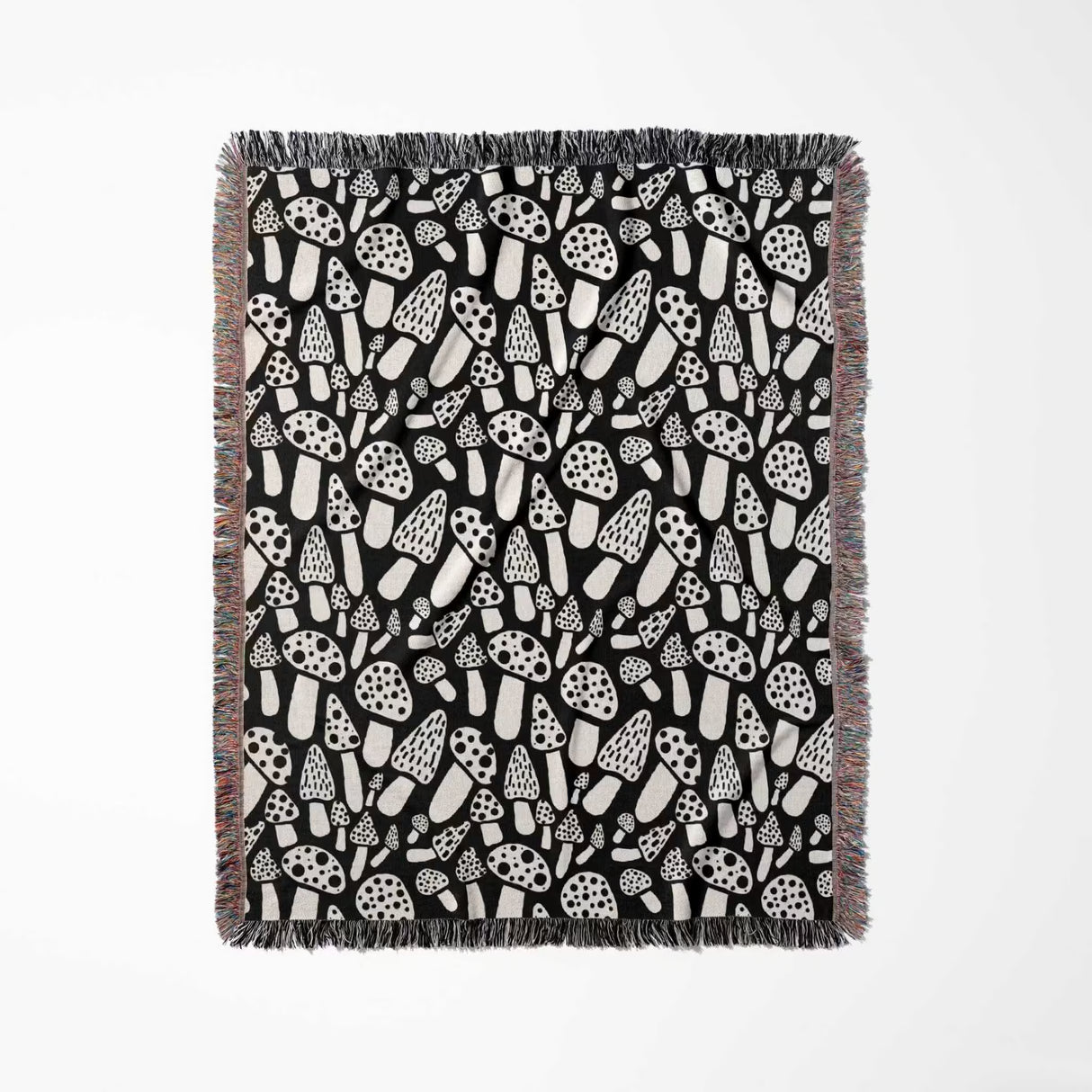 Black and white mushrooms patterned woven blanket throw full view on a light gray background.