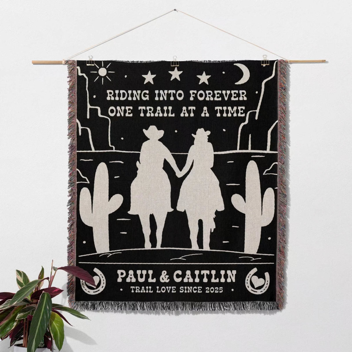Personalized cowboy and cowgirl 2nd anniversary gift woven throw blanket as wall art tapestry with desert scene design, text, and silhouettes of a couple holding hands.
