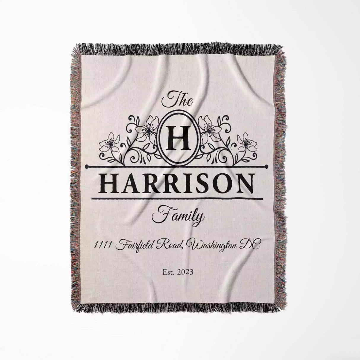 Personalized family name and address blanket with 'Harrison Family' design flat lay on a white background
