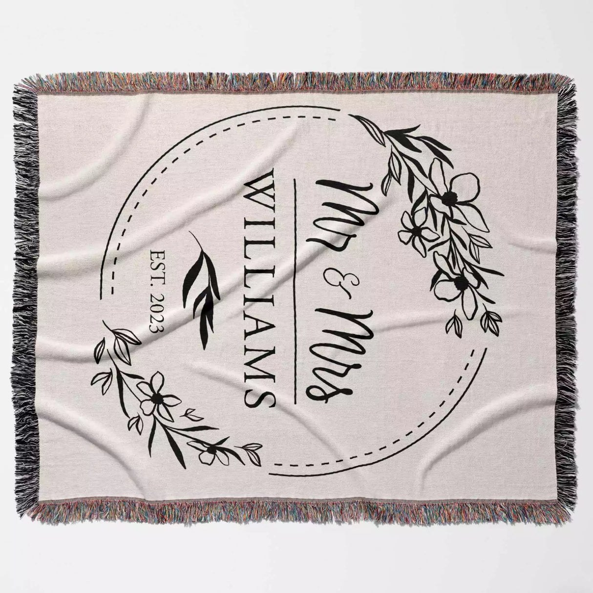 Personalized blanket with 'Mr & Mrs' and 'Williams' text, floral design, and year flat lay on a light background