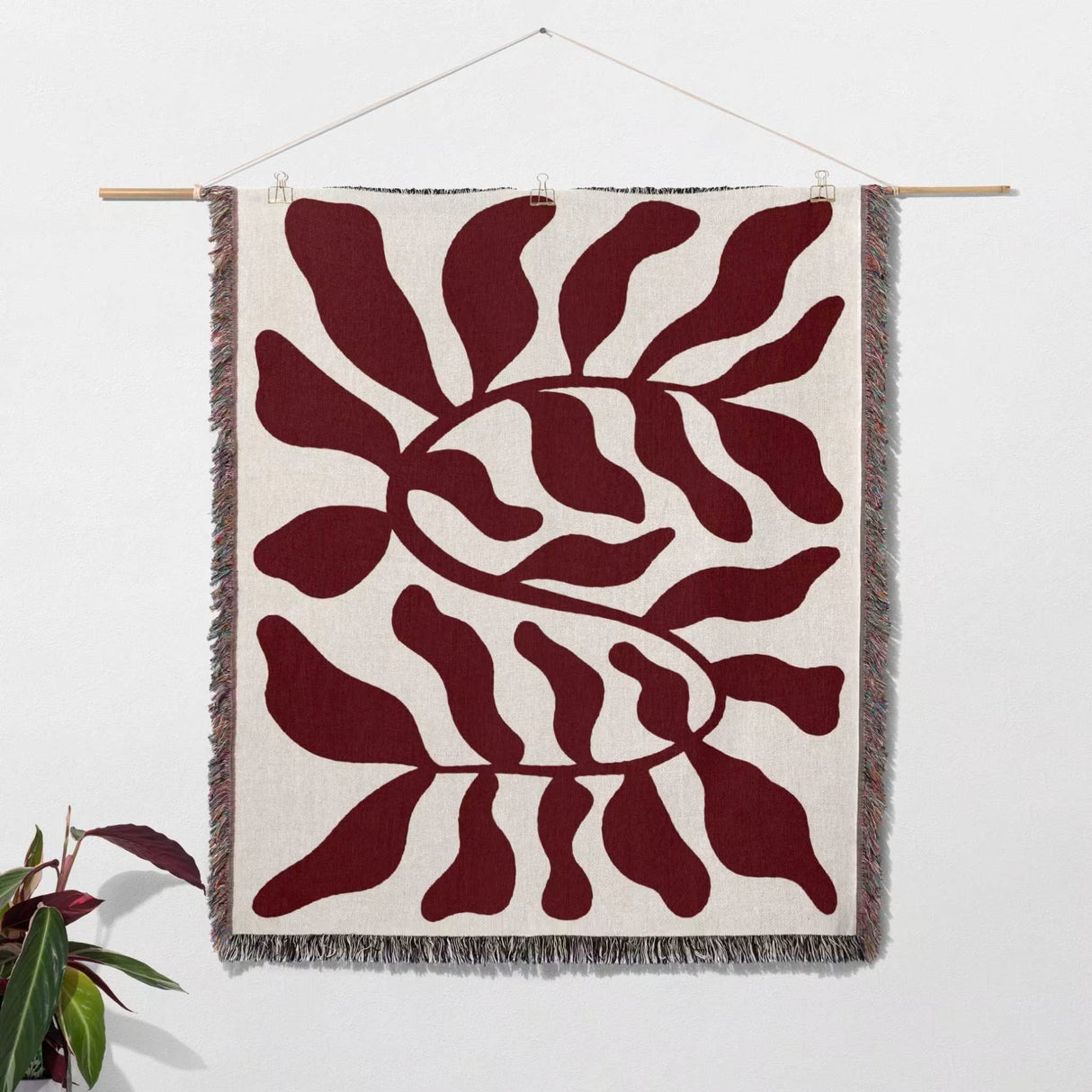 Red leaf Matisse throw blanket as woven wall art hanging on a white background