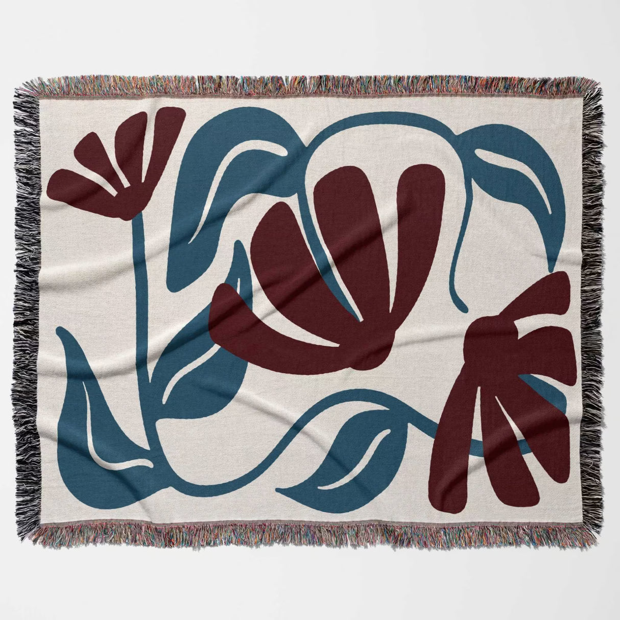 Red and blue Matisse tapestry throw blanket flat horizontally on a beige background