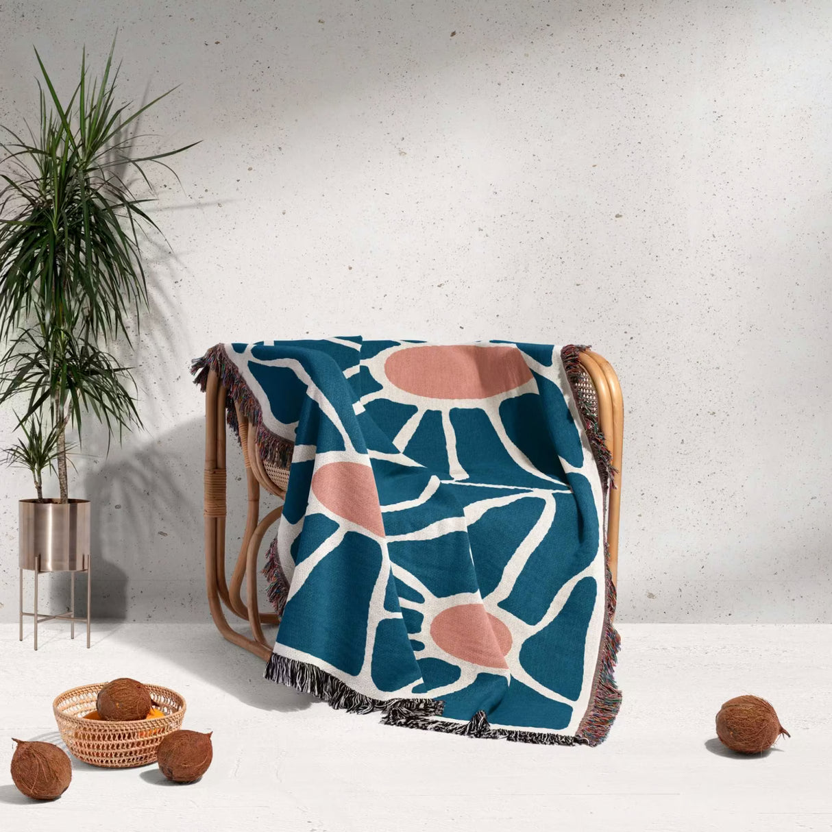 Decorative retro style Matisse inspired tapestry throw blanket for couch draped over a chair in a room with a plant and decorative items.