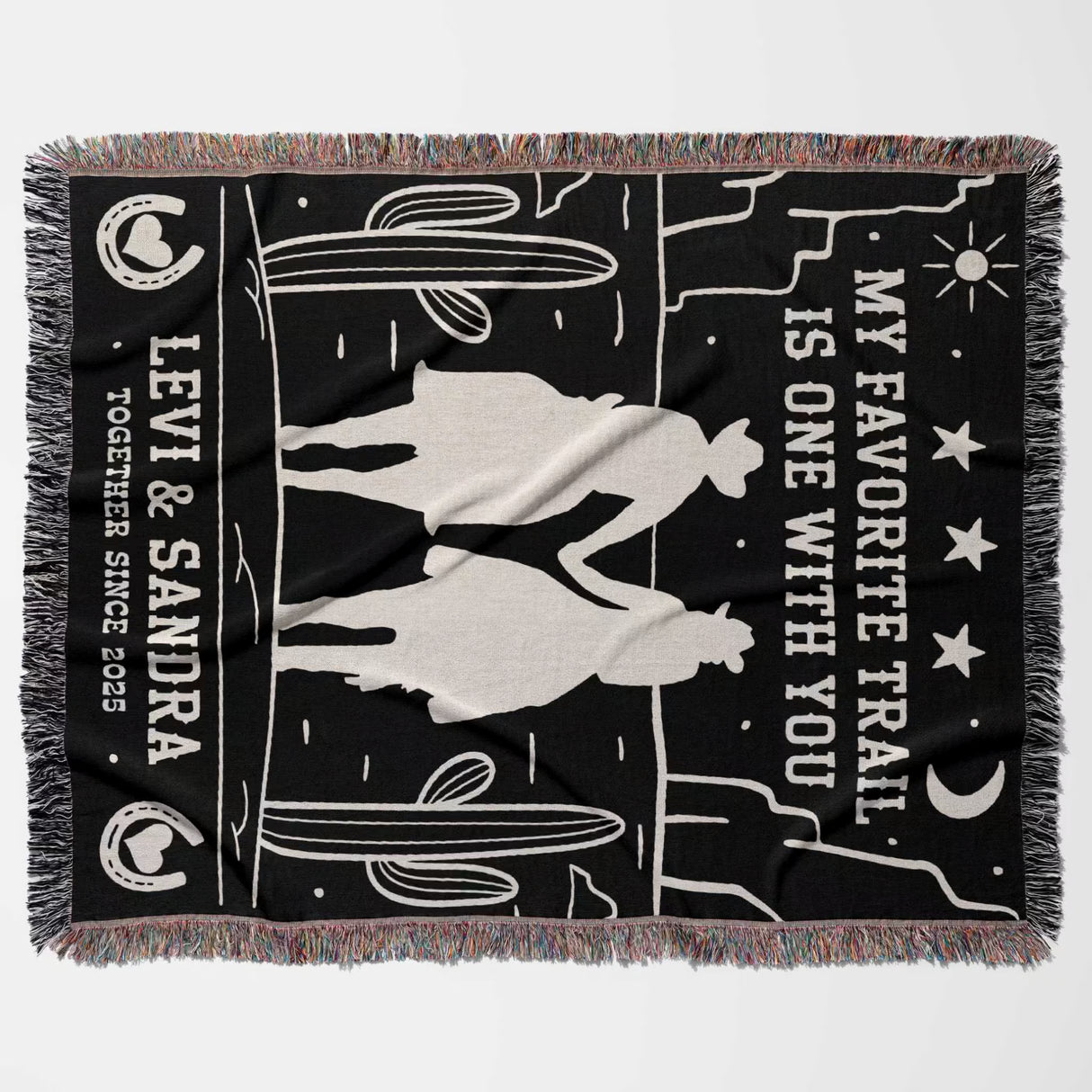 Romantic cowboy and cowgirl 2nd anniversary gift woven throw blanket flat lay with horse silhouettes and text on a black background