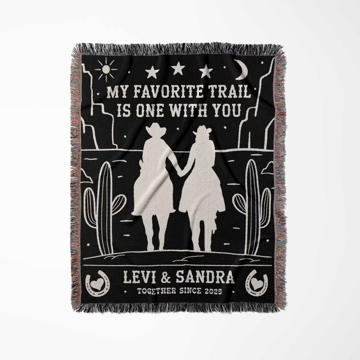 Romantic cowboy and cowgirl 2nd anniversary gift woven throw blanket full view with desert design, couple holding hands, and personalized text on a black background.