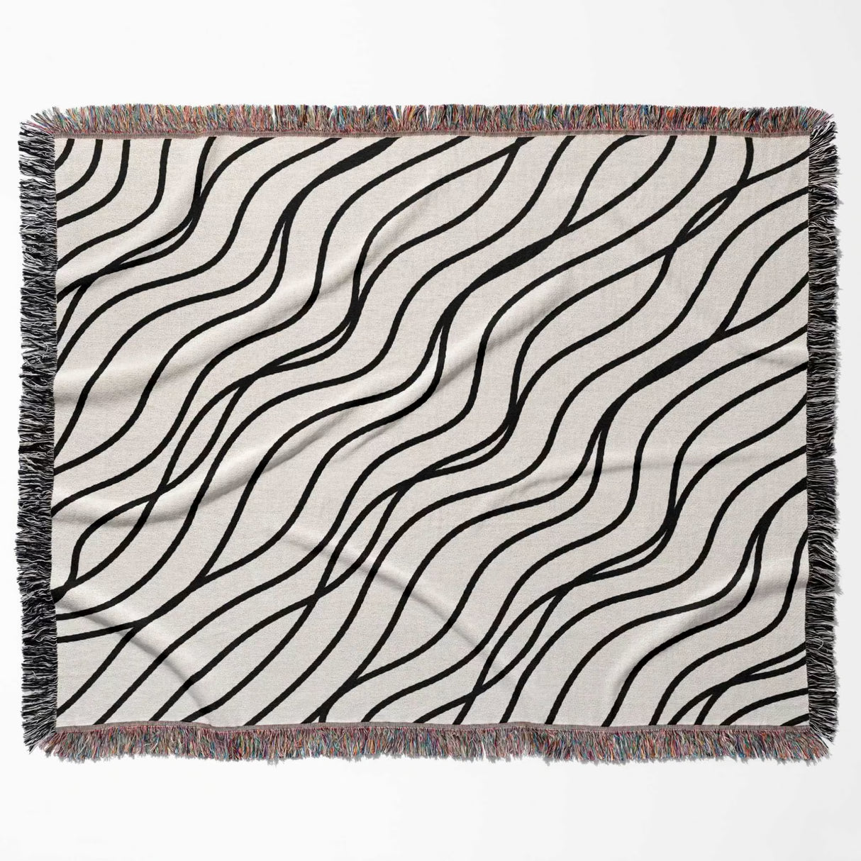 Black and white simple curly lines woven blanket throw full view on a beige background.